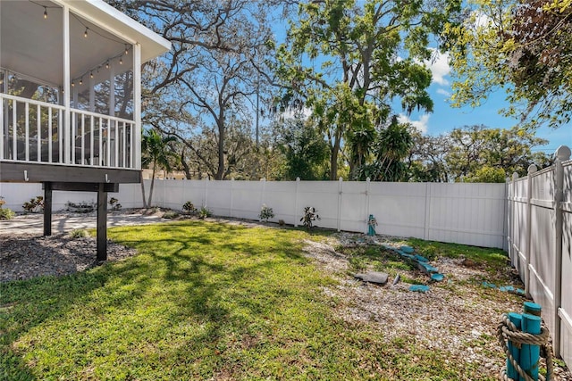 view of yard with a fenced backyard and a sunroom