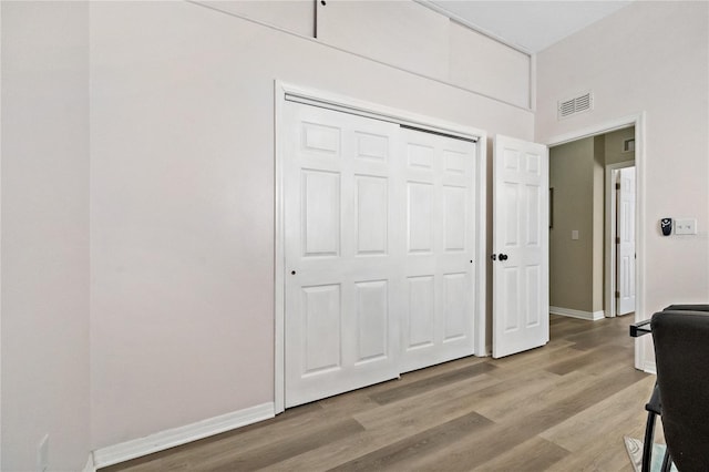 interior space with light wood finished floors, baseboards, visible vents, and a closet