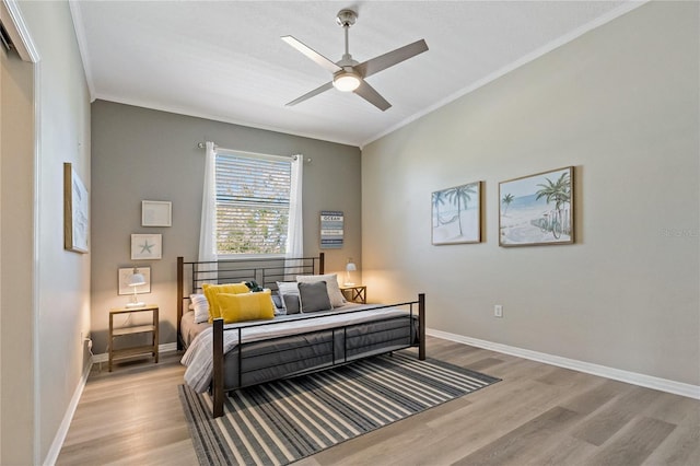bedroom with wood finished floors, ceiling fan, baseboards, and ornamental molding