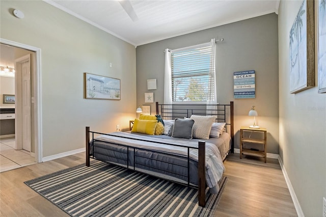 bedroom with ornamental molding, baseboards, and light wood finished floors