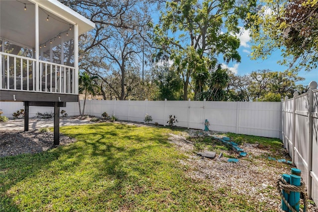 view of yard featuring a fenced backyard and a sunroom