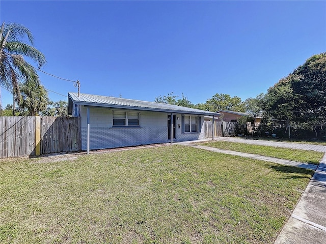 view of front of house with metal roof, a front yard, and fence