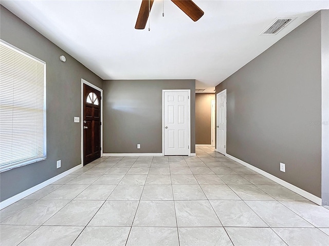 interior space with light tile patterned floors, visible vents, baseboards, and ceiling fan