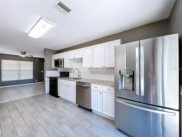 kitchen with visible vents, a sink, tasteful backsplash, white cabinetry, and appliances with stainless steel finishes