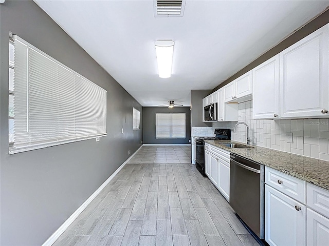 kitchen with visible vents, decorative backsplash, appliances with stainless steel finishes, a ceiling fan, and a sink