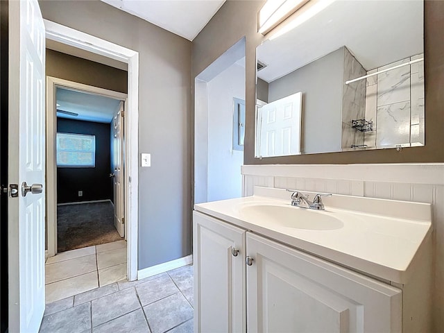 bathroom with a shower, baseboards, vanity, and tile patterned flooring