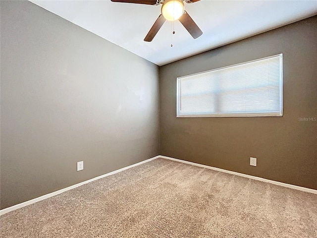 unfurnished room with ceiling fan, baseboards, and carpet