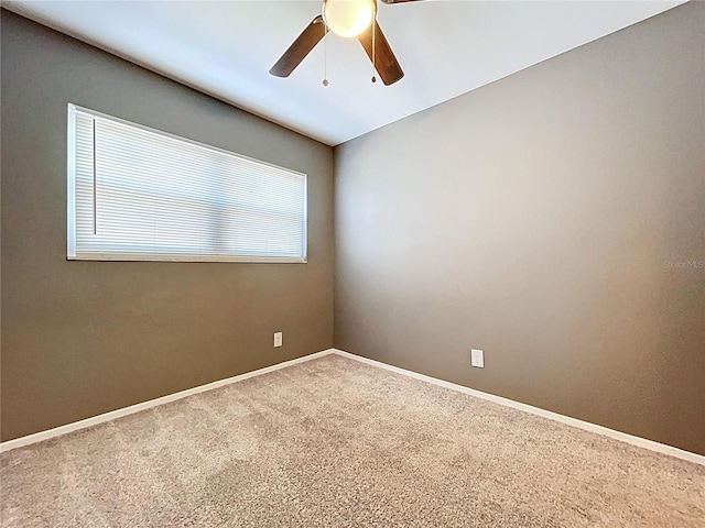 spare room with carpet flooring, baseboards, and a ceiling fan