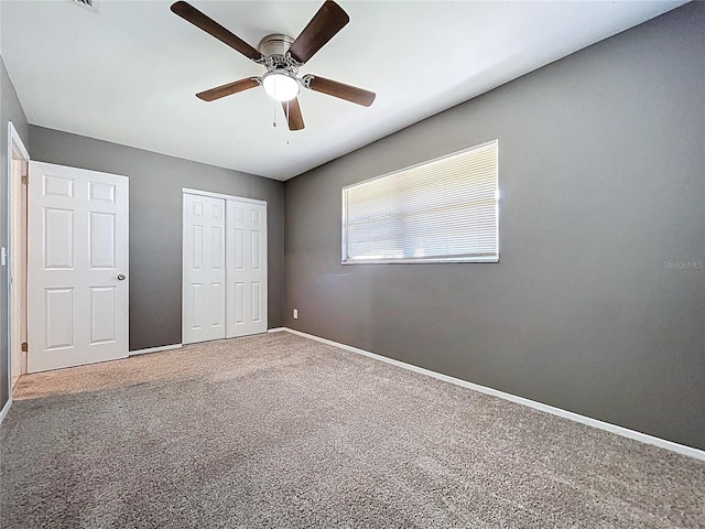 unfurnished bedroom featuring a closet, carpet flooring, ceiling fan, and baseboards