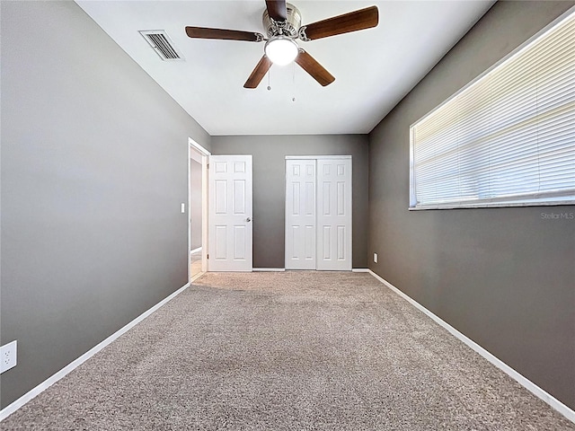 unfurnished bedroom featuring a closet, visible vents, baseboards, and carpet