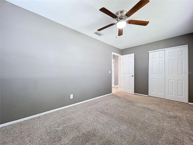 unfurnished bedroom with visible vents, a closet, carpet, baseboards, and ceiling fan