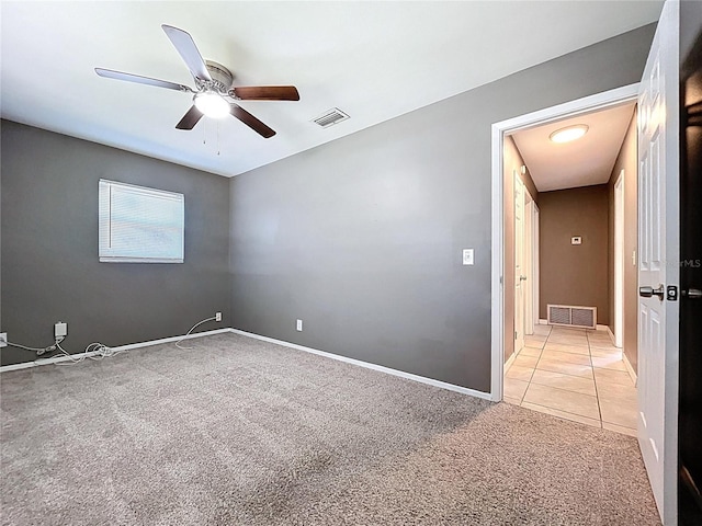 unfurnished room featuring visible vents, baseboards, light colored carpet, and a ceiling fan