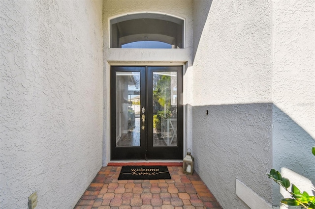 property entrance featuring french doors and stucco siding