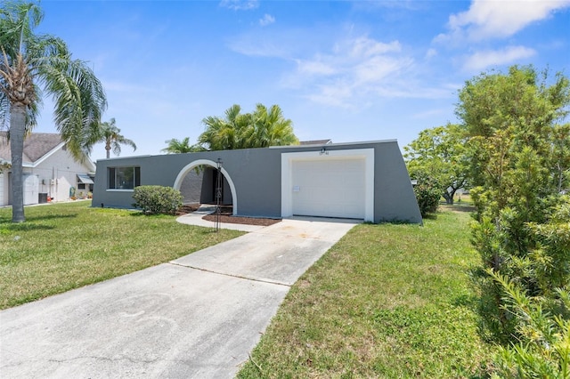 view of front of home with a garage, stucco siding, concrete driveway, and a front yard