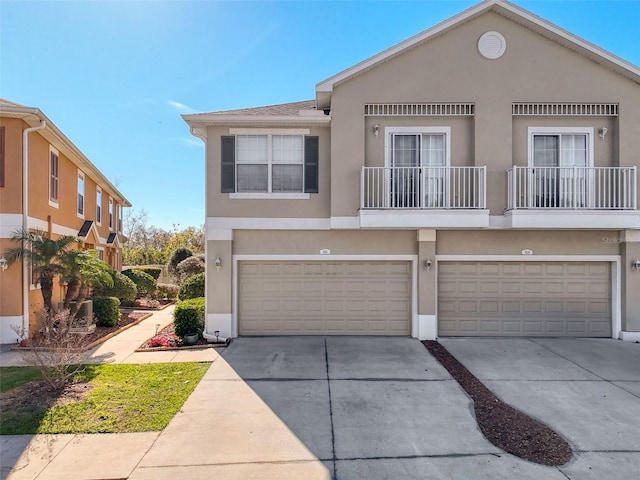 townhome / multi-family property with stucco siding, concrete driveway, and a garage