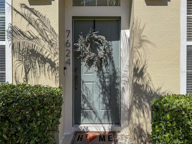 doorway to property featuring stucco siding