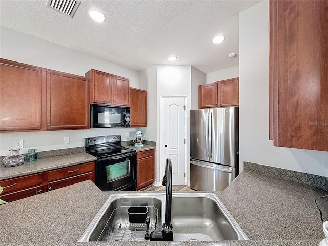 kitchen with visible vents, black appliances, recessed lighting, a textured ceiling, and a sink