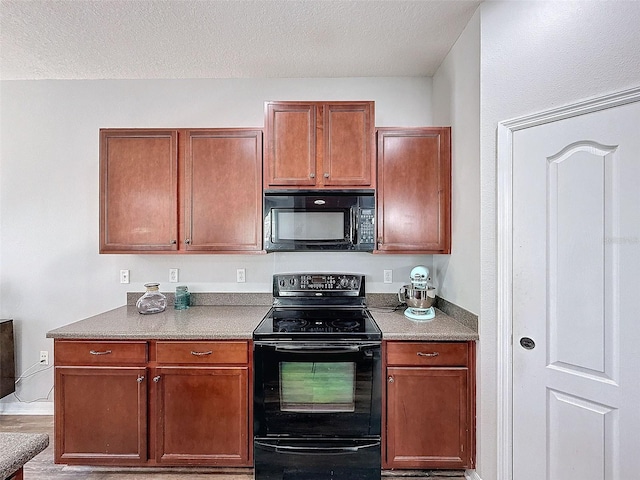 kitchen featuring a textured ceiling and black appliances