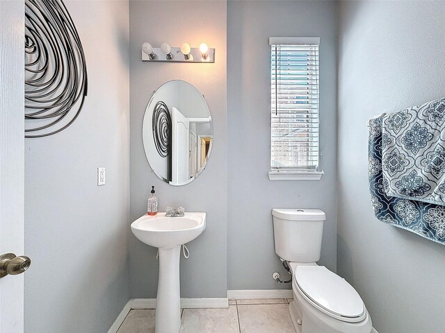 bathroom featuring tile patterned flooring, toilet, and baseboards