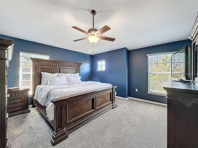 bedroom with a ceiling fan, baseboards, carpet floors, and a textured ceiling