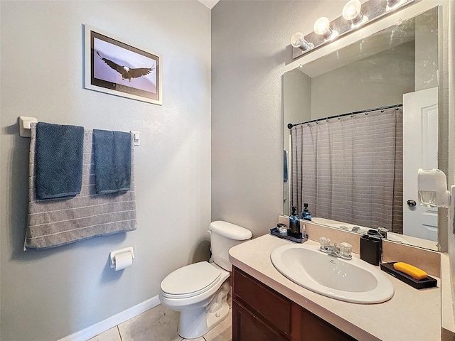 bathroom featuring tile patterned floors, toilet, vanity, and baseboards