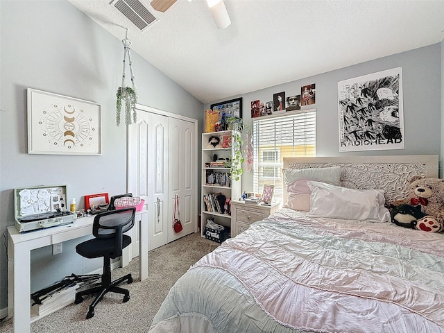 carpeted bedroom with visible vents, lofted ceiling, a closet, a textured ceiling, and a ceiling fan