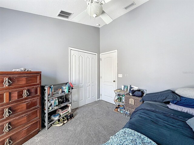 carpeted bedroom featuring vaulted ceiling, visible vents, a closet, and ceiling fan