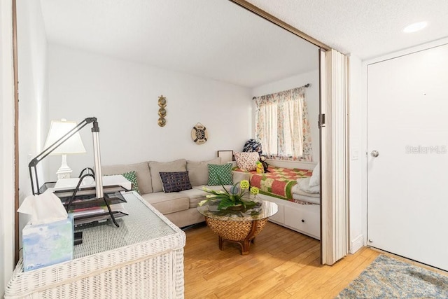 living room with a textured ceiling and light wood-type flooring