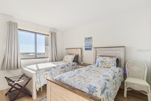 bedroom with wood finished floors and a textured ceiling