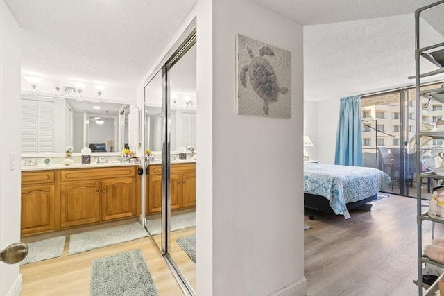 full bath featuring wood finished floors, a textured ceiling, ensuite bath, and vanity