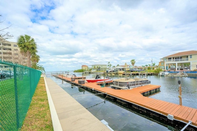 view of dock with fence and a water view