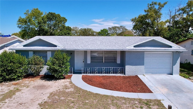 ranch-style home with roof with shingles, covered porch, concrete driveway, a garage, and brick siding