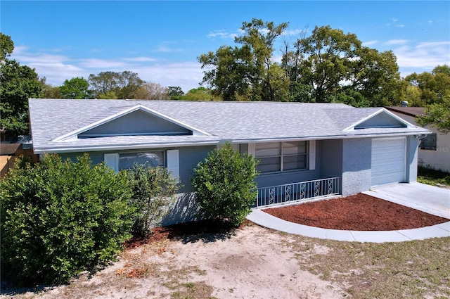 ranch-style home featuring concrete driveway, a garage, brick siding, and roof with shingles