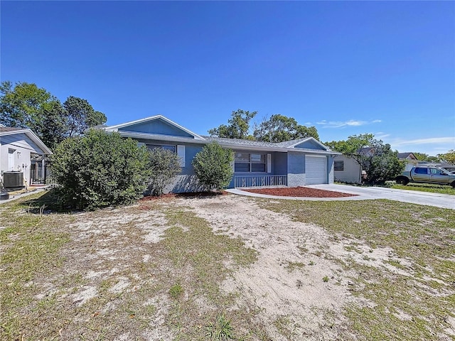 single story home featuring cooling unit, driveway, and an attached garage