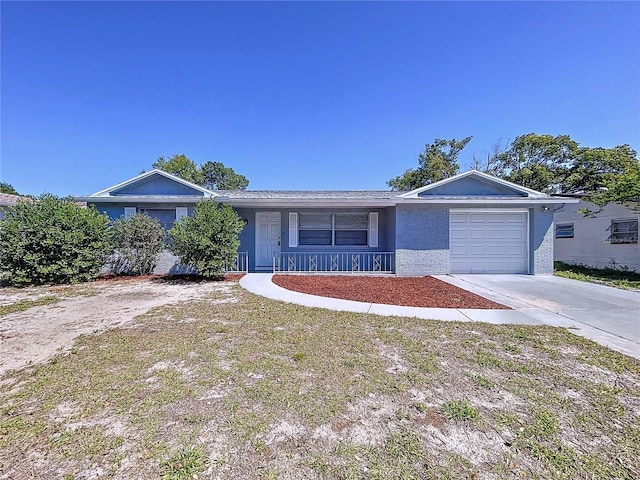 ranch-style home featuring brick siding, covered porch, concrete driveway, and a garage