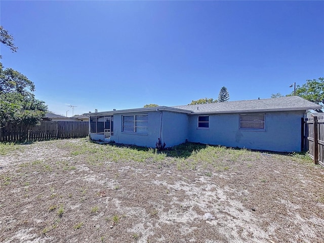 back of property featuring stucco siding and fence