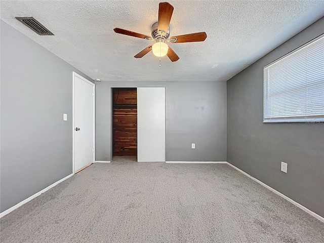 unfurnished bedroom featuring visible vents, a ceiling fan, a closet, carpet, and baseboards