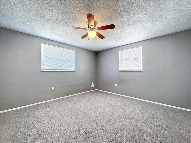 carpeted empty room featuring baseboards, a textured ceiling, and ceiling fan