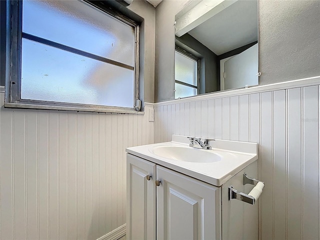 bathroom with vanity and a wainscoted wall