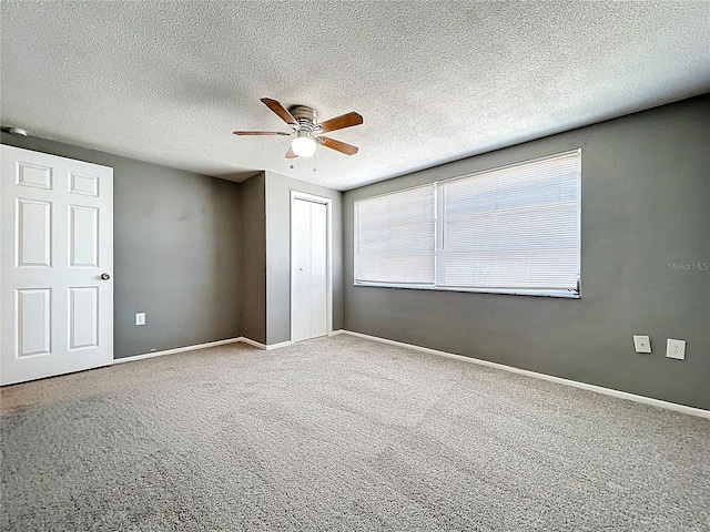 unfurnished bedroom with a closet, baseboards, carpet, and a ceiling fan