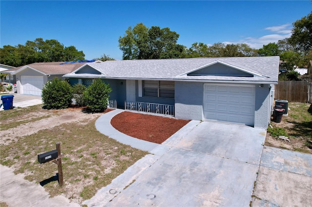 ranch-style house featuring fence, covered porch, concrete driveway, a garage, and brick siding