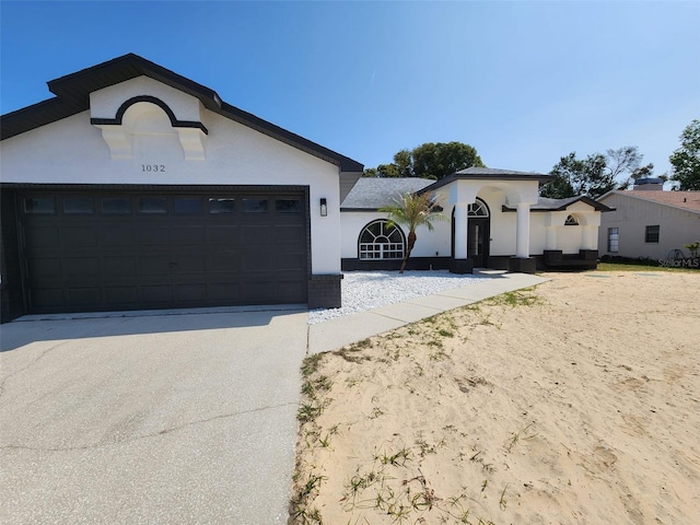 view of front of property with a garage, driveway, and stucco siding