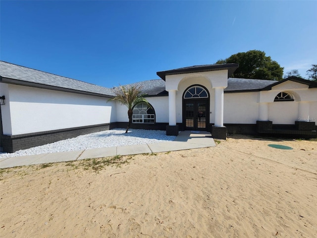 view of front of house with french doors and stucco siding