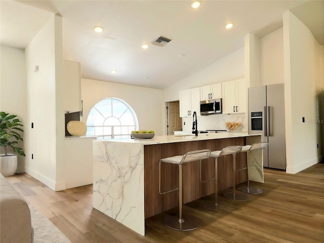 1032 Concert Ave, Spring Hill, FL 34609 - kitchen with stainless steel microwave, visible vents, fridge with ice dispenser, white cabinetry, and a sink