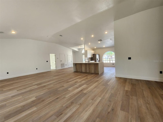 1032 Concert Ave, Spring Hill, FL 34609 - unfurnished living room featuring recessed lighting, light wood-style flooring, baseboards, and vaulted ceiling