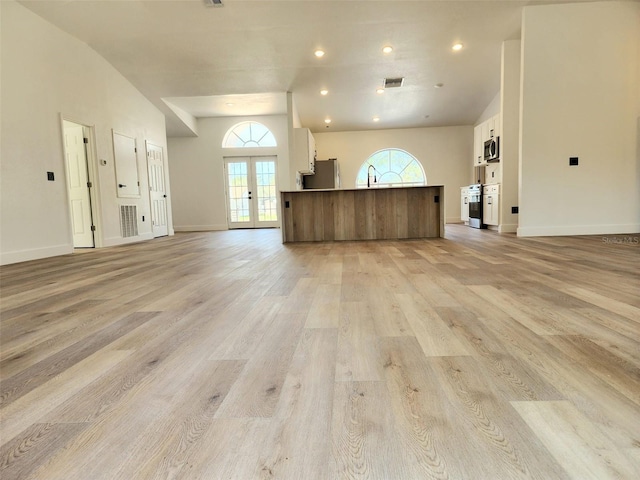 1032 Concert Ave, Spring Hill, FL 34609 - unfurnished living room with visible vents, light wood-style flooring, french doors, and baseboards