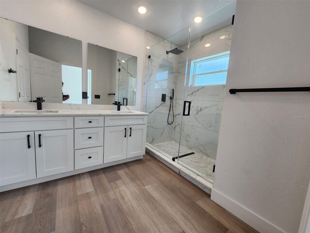 1032 Concert Ave, Spring Hill, FL 34609 - bathroom featuring a marble finish shower, double vanity, wood finished floors, and a sink