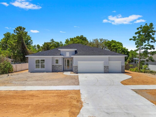 5413 Deltona Blvd, Spring Hill, FL 34606 - ranch-style home with fence, stone siding, stucco siding, an attached garage, and driveway