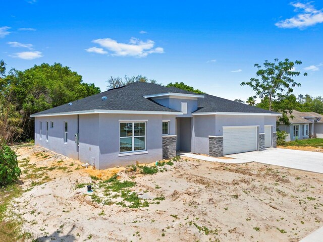 5413 Deltona Blvd, Spring Hill, FL 34606 - prairie-style home featuring stucco siding, an attached garage, driveway, and stone siding