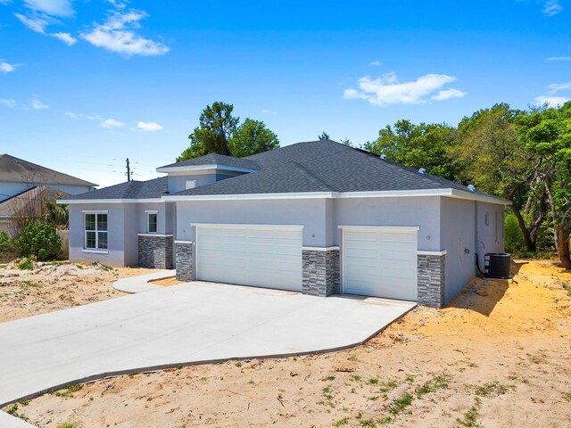 5413 Deltona Blvd, Spring Hill, FL 34606 - view of front of property featuring central AC unit, a garage, concrete driveway, stone siding, and stucco siding